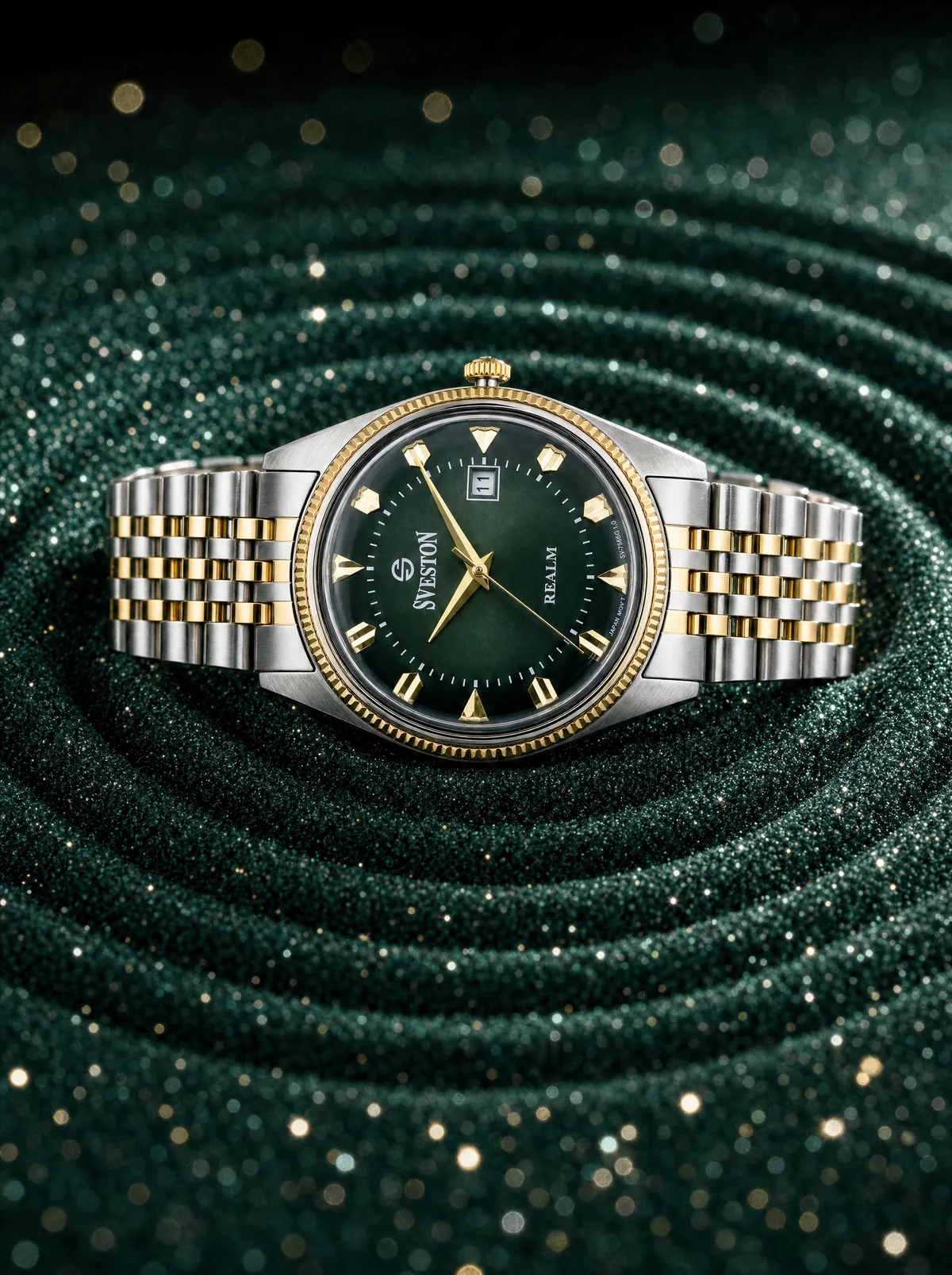 Gold and emerald Sveston watch on a textured green setting