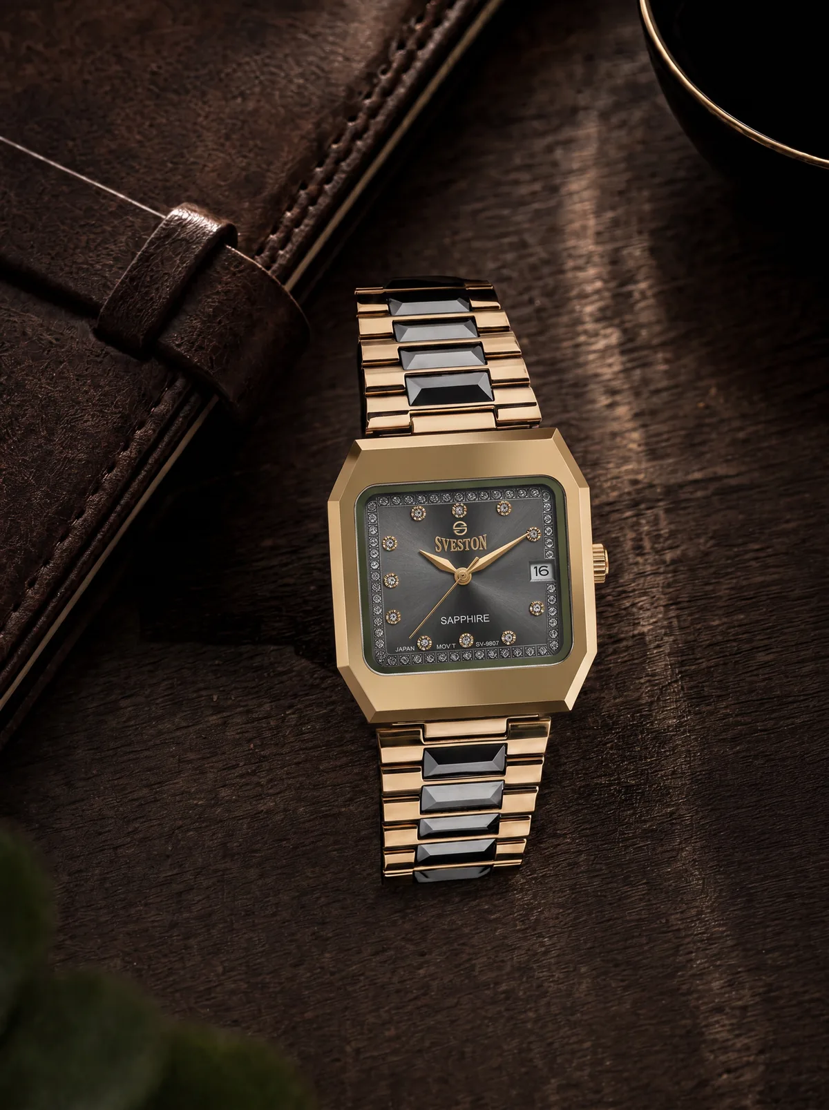 Black and gold Sveston watch arranged on a dark leather desk