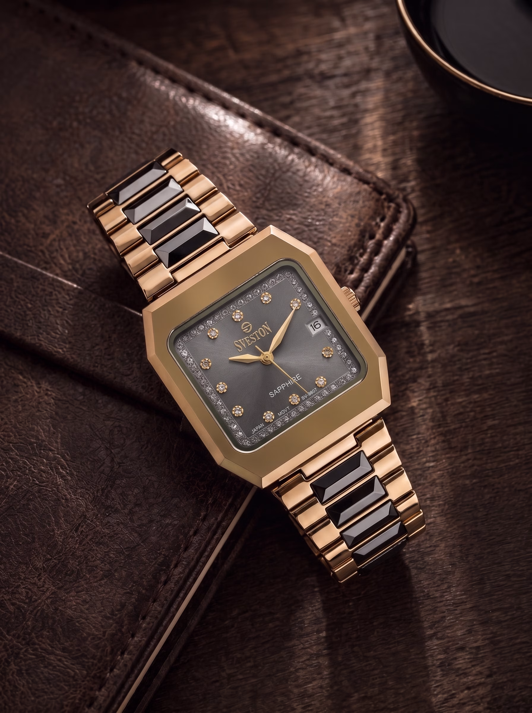 Black and gold Sveston chronograph displayed in a dramatic after-dark garden setting